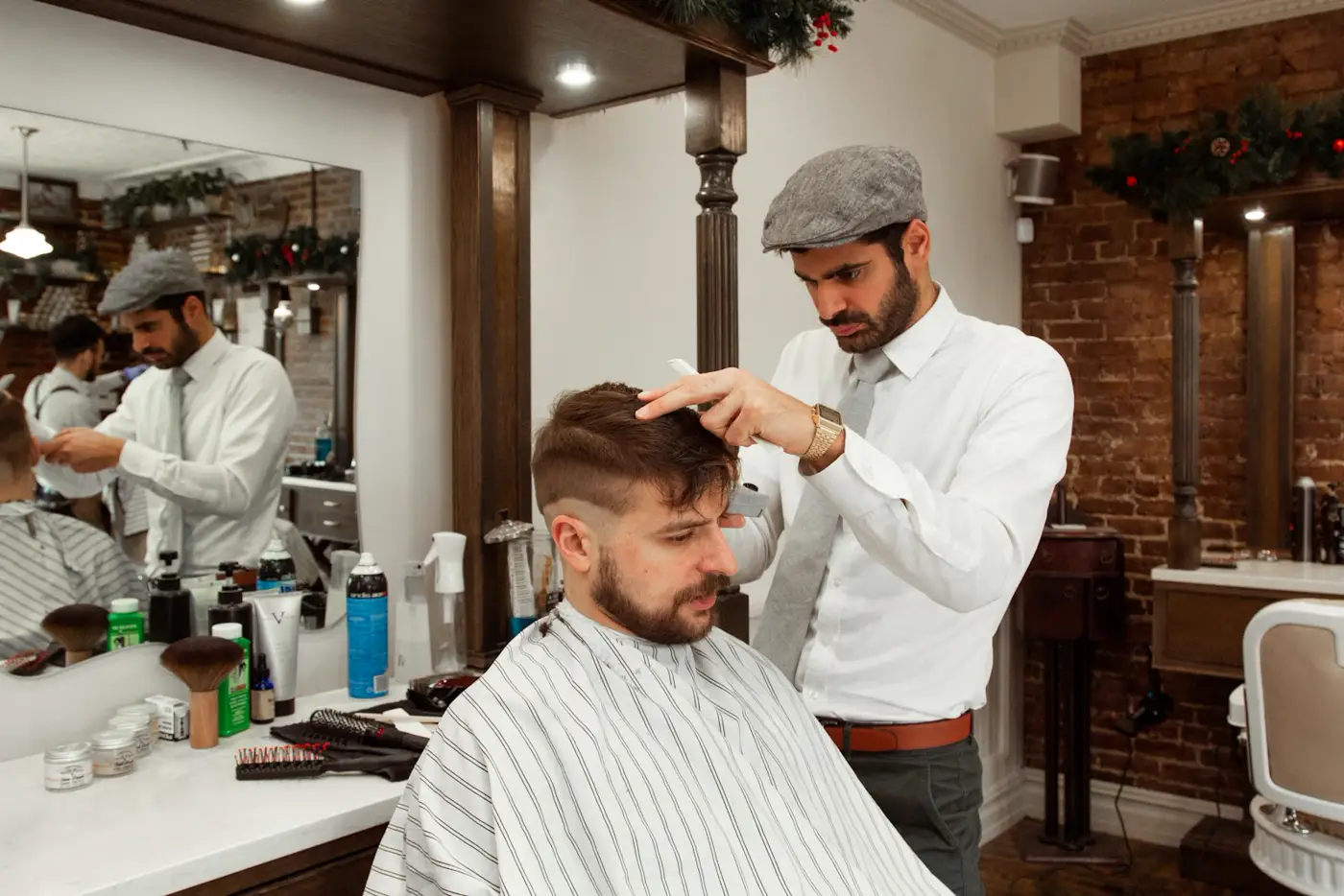 Barbero de El Compás cortando con tijera frente al espejo